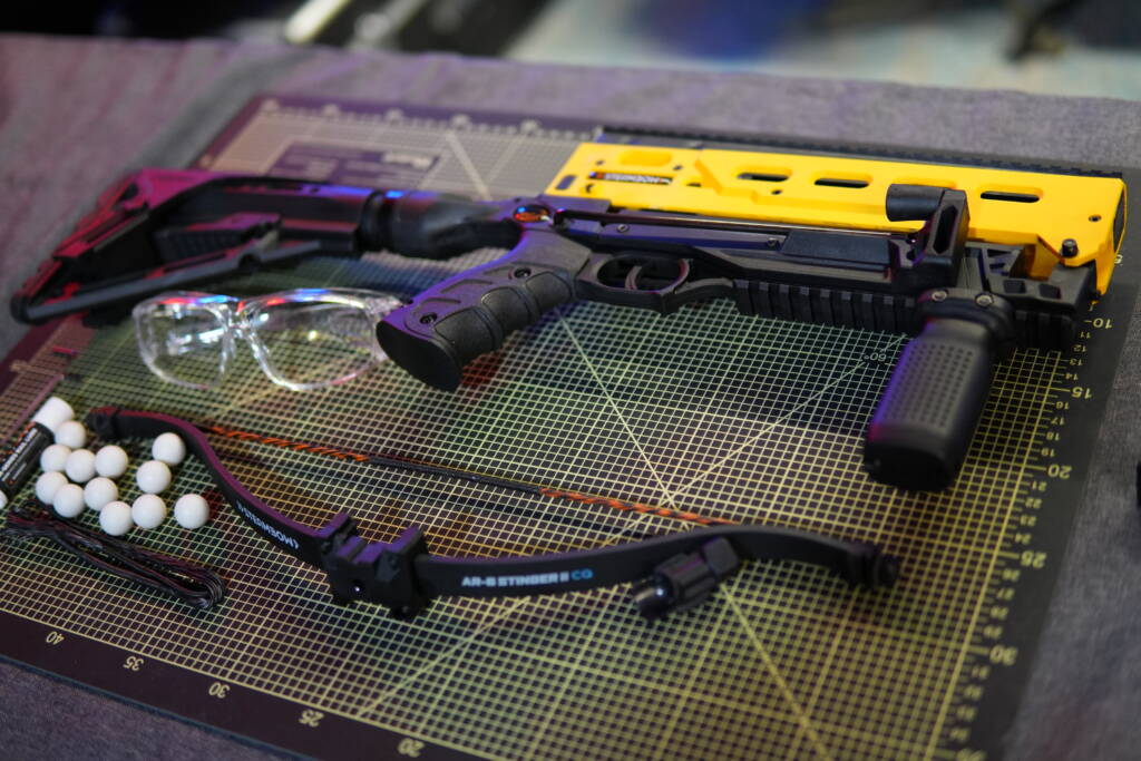 Contents of the B08 less-lethal crossbow package including upper and lower receiver, stock, grip, CQ limb, magazine sled, ammunition, spare string, maintenance tools, and safety glasses.
