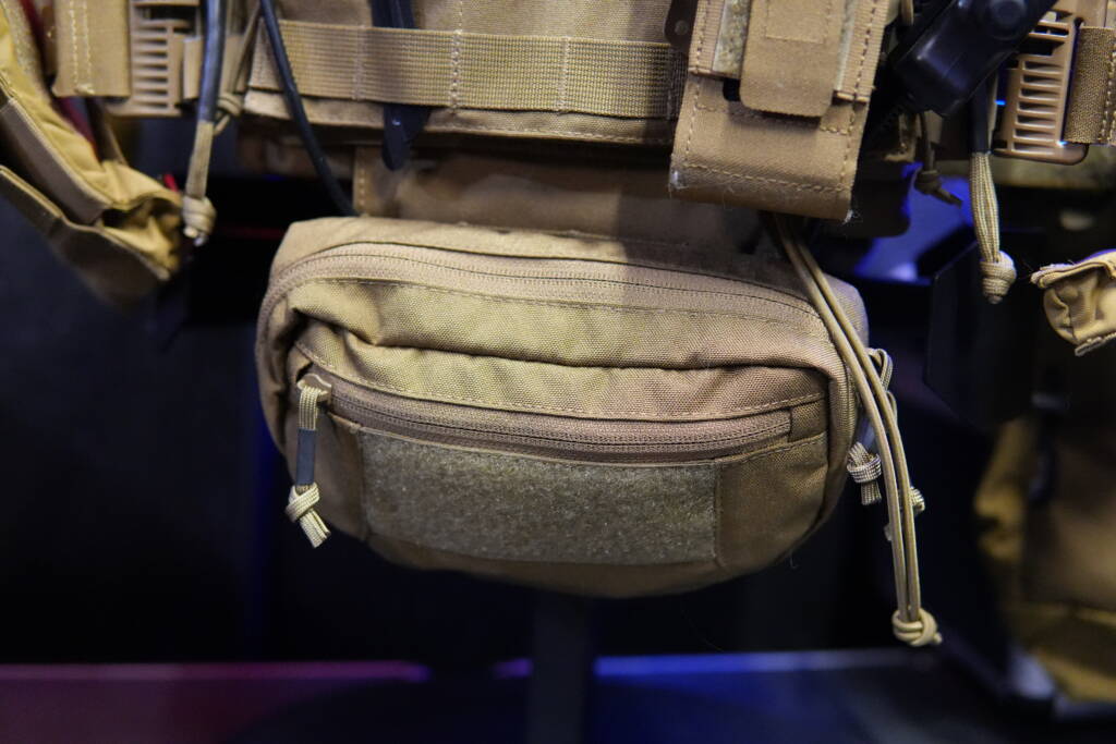 Helikon-Tex Guardian Dangler Pouch mounted under a plate carrier, close-up view of zipper and hook-and-loop panel