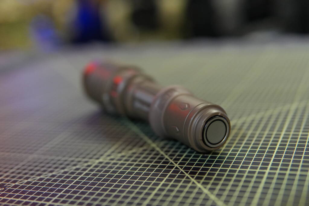 Rear view of Olight Warrior X4 tactical flashlight showing magnetic tail switch and charging interface.