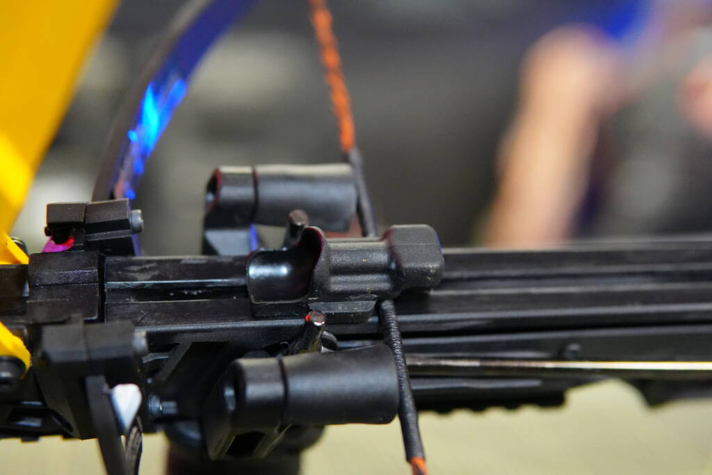 Projectile carrier sled positioned on the rail of the Steambow B08 crossbow, attached to the string and ready for firing.