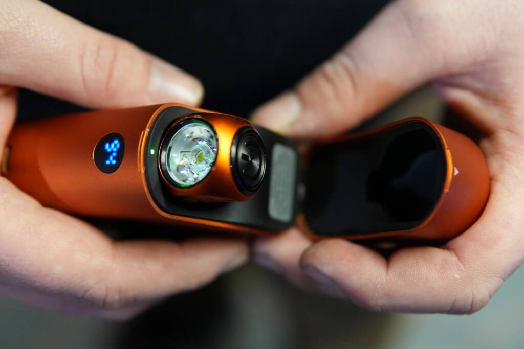 Olight Perun 3 Mini charging inside its open charging case with 94% battery indicator visible.