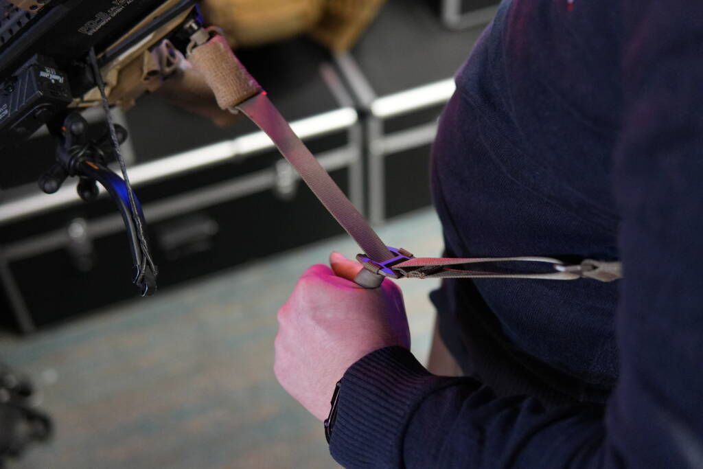 Agilite Reflex3D Sling quick-adjust system being tightened by hand while attached to a firearm.