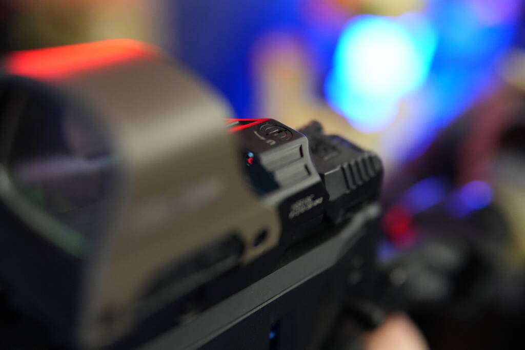 Mantis X10 mounted behind a red dot sight on a Picatinny rail.