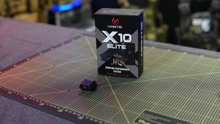 Mantis X10 Elite digital shooting trainer sensor and packaging on a cutting mat.