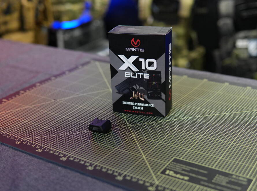 Mantis X10 Elite digital shooting trainer sensor and packaging on a cutting mat.