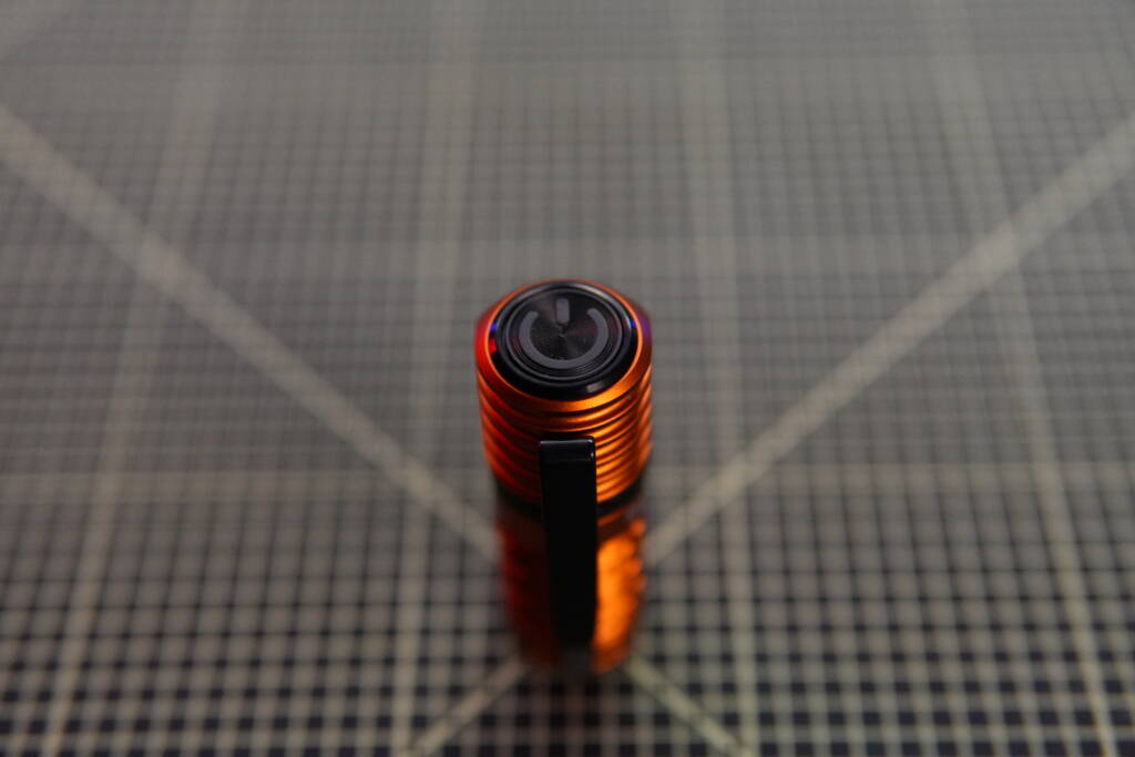 Top view of Olight Perun 3 Mini showing the single control button on the head of the flashlight.