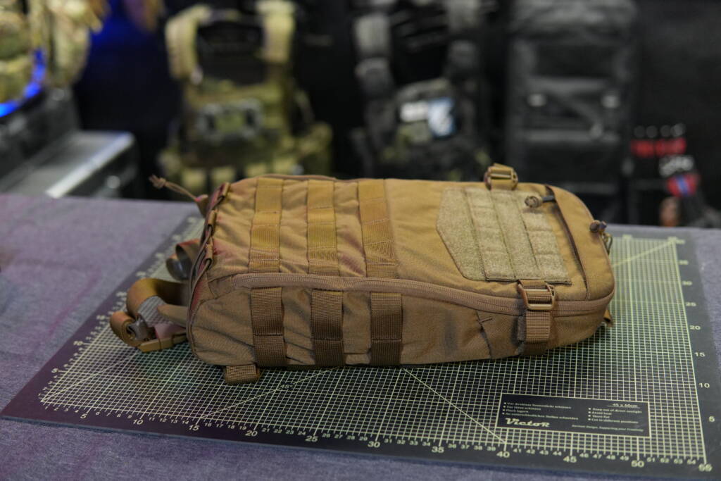 Helikon-Tex Guardian Small Pack in Coyote color filled with water bottles, shown on a cutting mat.