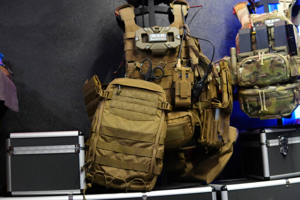 Helikon-Tex Guardian Small Pack positioned in front of a Guardian Plate Carrier, showing modular compatibility via MOLLE system.