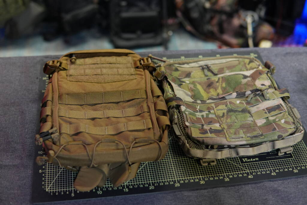 Helikon-Tex Guardian Small Pack next to Agilite Micro MAP backpack panel on a cutting mat for size and design comparison.